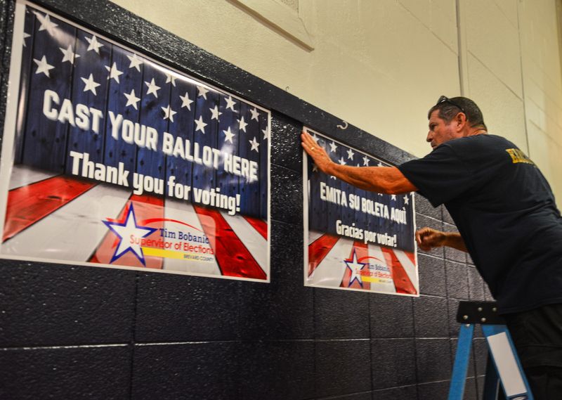 Edward Smith with the Supervisor of Elections office puts up posters in the Kiwanis Island gym. Workers for the Supervisor of Elections office were busy this week setting up the 10 early voting sites around the county. Early voting runs Saturday the 8th -15th at the sites.