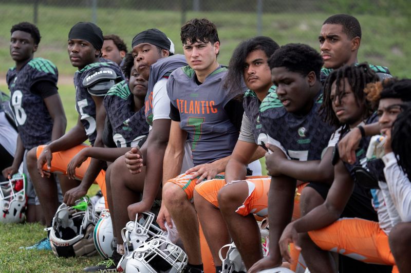Players take a knee after practice as they listen to coaches at Atlantic high school football practice in Delray Beach, Florida on August, 5, 2026.