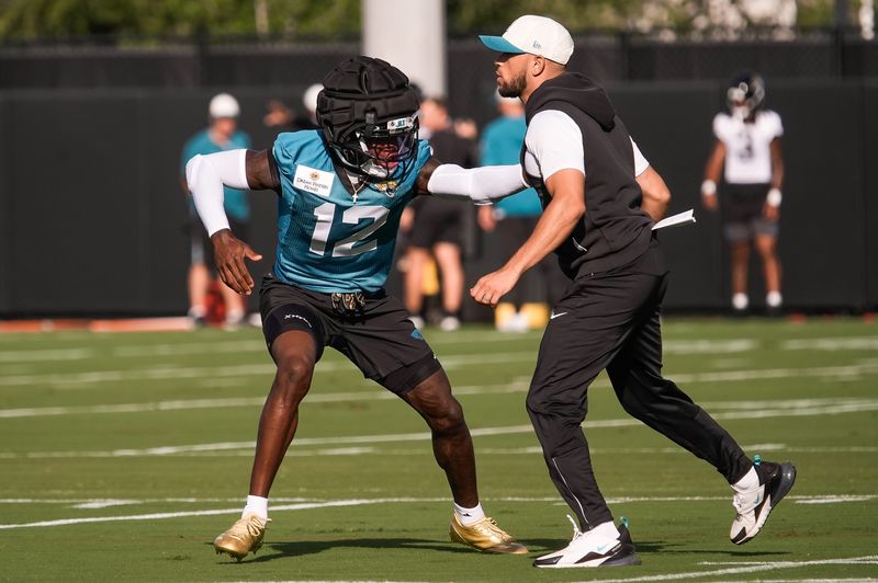 Jacksonville Jaguars Cornerback/Wide Receiver Travis Hunter (12) runs drills with Defensive Backs Coach Anthony Perkins during the Jacksonville Jaguars 10th day of NFL Training Camp at the Miller Electric Center in Jacksonville, Fla., Sunday, August 9, 2026.    [Doug Engle/Florida Times-Union]