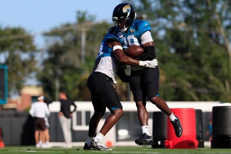 Jacksonville Jaguars safety Eric Murray (29) is touch tackled by safety Trevian Thomas (34) during Day 11 of NFL training camp at the Miller Electric Center on Tuesday, Aug. 11, 2026, in Jacksonville, Fla.