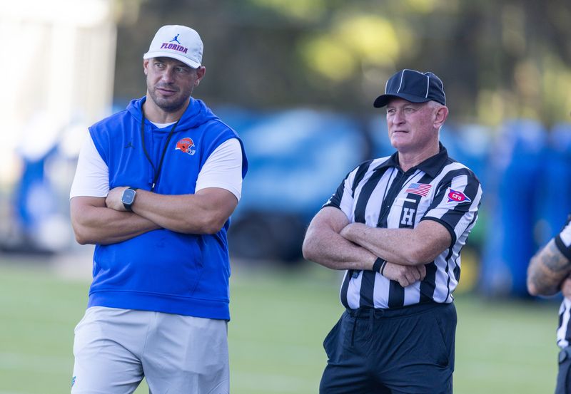 Florida Head Coach Jon Sumrall, left, watches practice with referees at Heavener Football Complex in Gainesville, FL on Tuesday, August 11, 2026. [Alan Youngblood/Gainesville Sun]