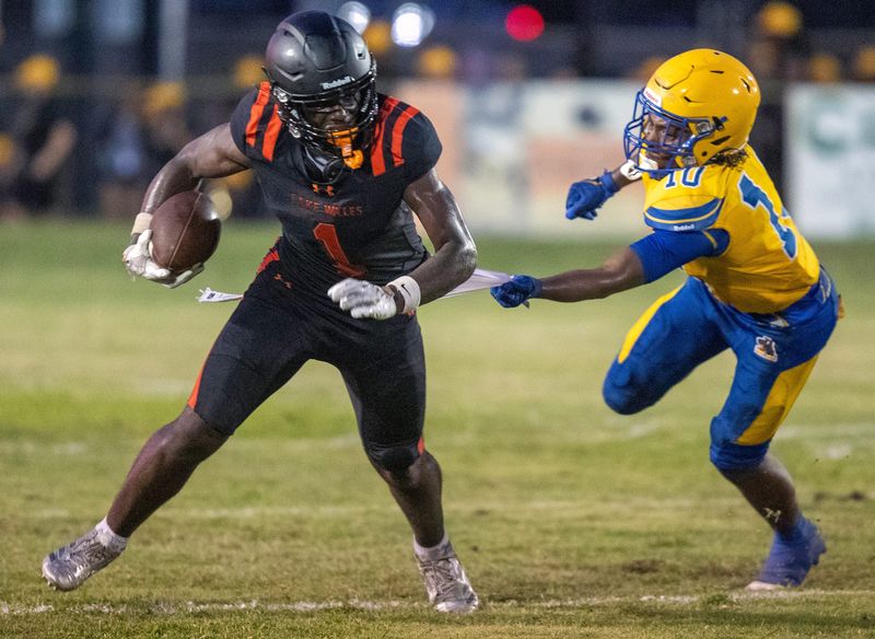 Lake Wales wide receiver Kaneilius Purdy breaks a tackle as Auburndale's Crystian Stevenson grabs for his jersey on Thursday night at Legion Field.
