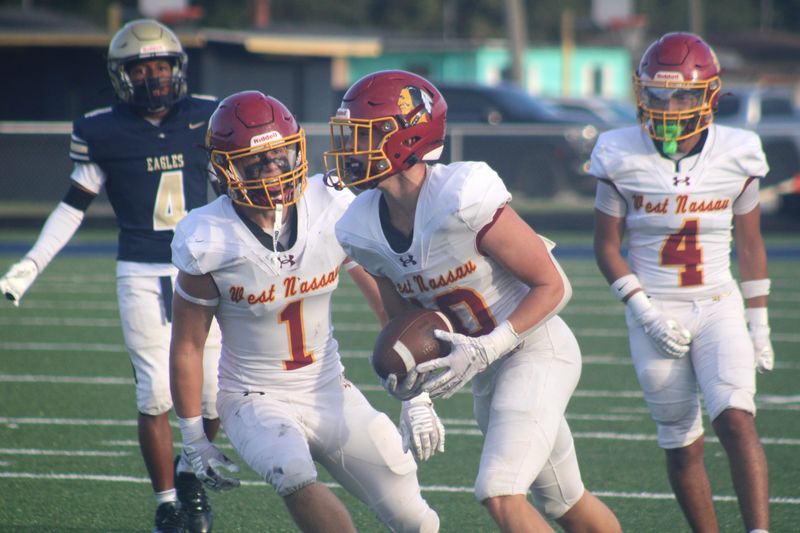 West Nassau defensive back Van Alexander (10) receives congratulations from linebacker Nate Batrous (1) and defensive back Blaine Coker (4) after an interception against Paxon during a high school football game on Aug. 14, 2026. [Clayton Freeman/Florida Times-Union]