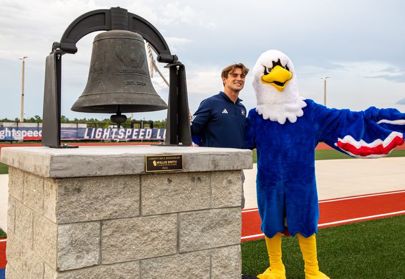 Wellen Park High School held its inaugural football game on Friday, Aug. 14, 2026 by hosting the North Port Bobcats. The Eagles won 45-7. Ethan Grossenbacher, left, and the Eagles mascot pose with the Wellen Park bell. Among the Eagles' first traditions is to ring the bell after each score.