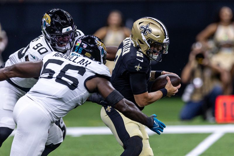 Aug 15, 2026; New Orleans, Louisiana, USA;  New Orleans Saints quarterback Spencer Rattler (2) scrambles from the pocket and fumbles the ball against Jacksonville Jaguars linebacker Yasir Abdullah (56) during the first half at Caesars Superdome. Mandatory Credit: Stephen Lew-Imagn Images