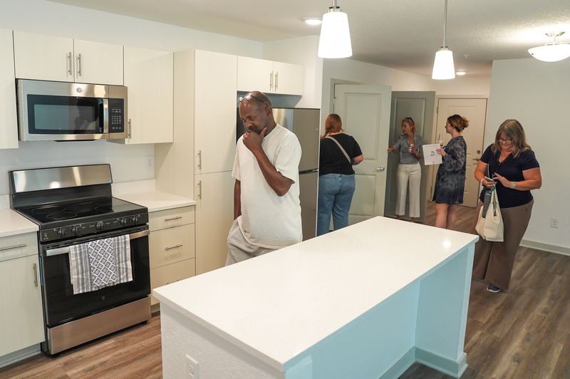 Anthony Bryson, left, a neighbor of the Village of New Augustine, checks out one of the apartment along with Debi Redding of the Homeless Coalition, right, on Aug. 18, in St. Augustine.