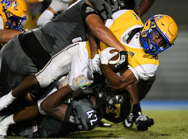 Treasure Coast defense tackles Martin County’s Arhmad Walker (4) in a high school football game, Aug. 21, 2026, at Martin County High School. Martin County won 17-14.