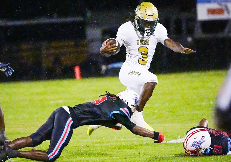 Raundae Monroe of Viera tries to leap the tackle of Rockledge defender Terrell Bell during their game August 21, 2026. Craig Bailey, FLORIDA TODAY via USA TODAY NETWORK
