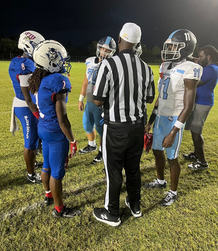 Team captains, including Pahokee's DJ Jones, left, and Dr. Joaquin Garcia's Zion Vilma, right, meet at midfield before an Aug. 21 game at Pahokee.