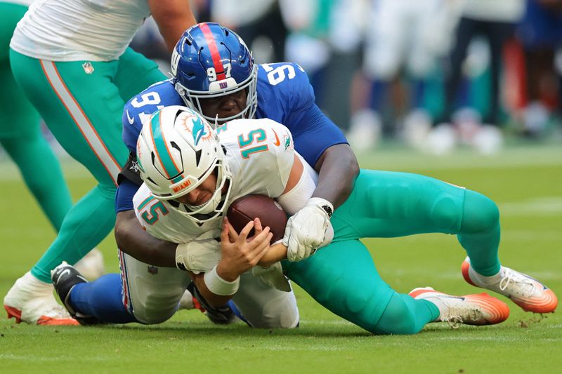 Aug 22, 2026; Miami Gardens, Florida, USA; Miami Dolphins quarterback Cam Miller (15) is sacked by New York Giants defensive tackle Bobby Jamison-Travis (97) during the first half at Hard Rock Stadium. Mandatory Credit: Sam Navarro-Imagn Images