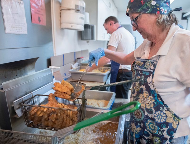 Cheryl Hudson works the fryer during the Knights of Columbus' weekly Lenten Fish Fry at the Cathedral of the Sacred Heart in Pensacola on Friday, March 4, 2022.