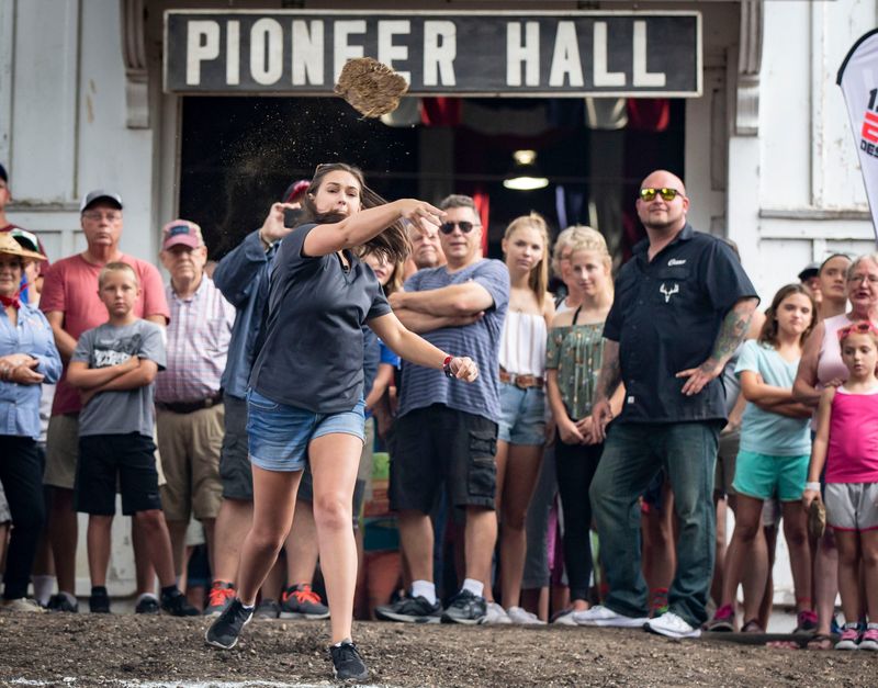 WHOTV's Maria Lisignoli tosses cow poop for distance in the Celebrity Cow Chip Throwing Contest at Pioneer Hall at the Iowa State Fair, Wednesday, Aug. 15, 2018, in Des Moines, Iowa.