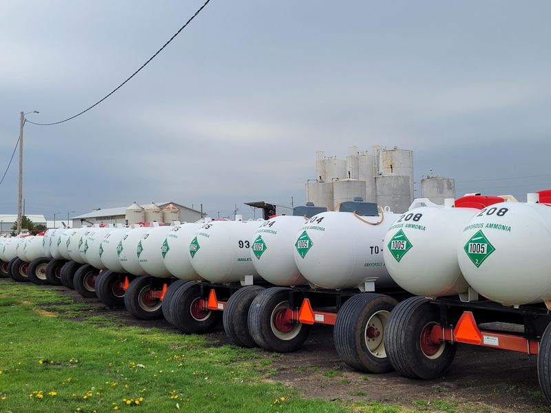 Ammonia fertilizer tanks line a storage yard in Tama County.