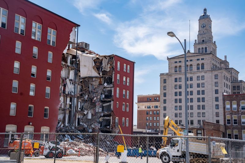 Workers secure the area a day after an apartment building partially collapsed in Davenport, Monday, May 29, 2023.