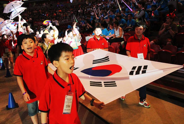 Students from South Korea march around Hilton Coliseum during the opening ceremonies of Odyssey of the Mind World Finals at Hilton Coliseum during the 2016 event. The creative problem-solving competition returns to Ames this week for the 2018 Finals. Ames Tribune file photo
