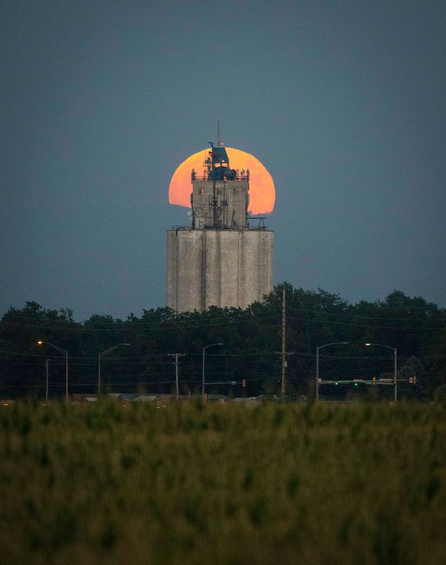 The full buck moon rises behind a grain elevator in Waukee, Iowa, on July 16, 2019. The full moon coincided with the 50th anniversary of the launch of Apollo 11 that year.
