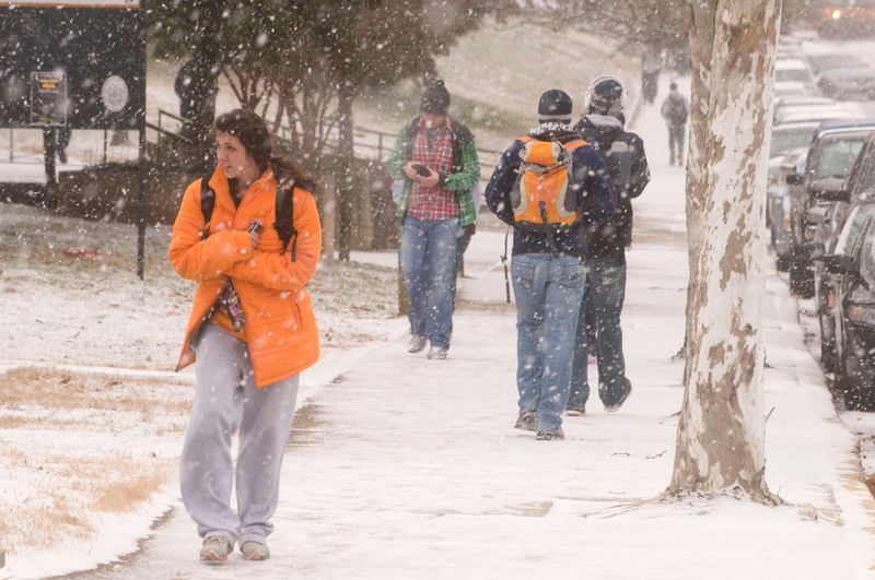 University of Tennessee Students head to class Weddnesday morning.

Cold air, gusty winds and accumulating snow showers across East Tennessee this morning have led to several school systems closing or opening late, and a winter storm warning has been issued for the Smoky Mountains.