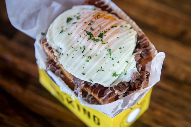 The Egg King's EggOGi sandwich is a breakfast sandwich topped with bulgogi beef and a sunny-side-up egg.