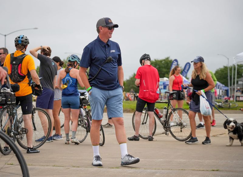 RAGBRAI director Matt Phippen visits with cyclists as they roll down to the dip site in Davenport during RAGBRAI on Saturday, July 29, 2023.
