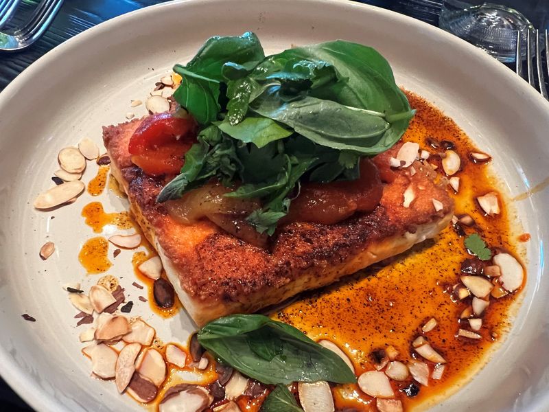 The baked feta from chef and owner Lynn Pritchard at Hugo's Wood-Fired Kitchen in the Drake neighborhood in Des Moines features roasted almonds and a chili oil.
