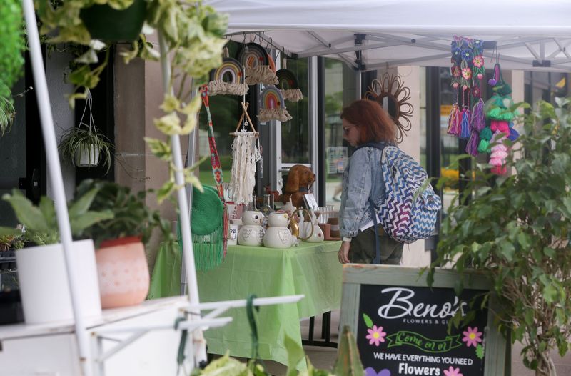 A person looks at items for sale outside of Beno’s Flowers & Gifts during the Sidewalk Sales Friday, July 19, 2024 in downtown Iowa City, Iowa.
