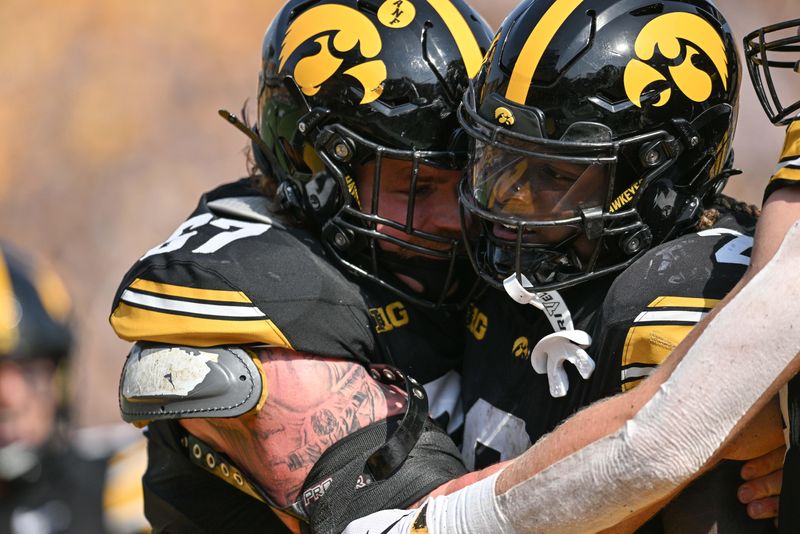 Oct 12, 2024; Iowa City, Iowa, USA; Iowa Hawkeyes running back Kaleb Johnson (2) reacts with offensive lineman Gennings Dunker (67) after his third touchdown run during the fourth quarter against the Washington Huskies at Kinnick Stadium. Mandatory Credit: Jeffrey Becker-Imagn Images