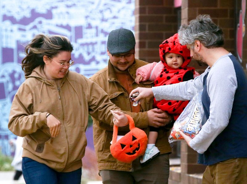 From left, Kaitlin Sandoval, Caleb, Sandoval and Bella Sandoval, 1, trick or treat Thursday, Oct. 31, 2024 in downtown in Iowa City, Iowa.