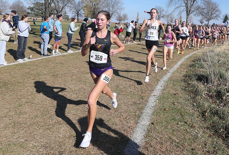 Johnston’s Alyx Woodley and Ames’ Lauren Risdal battle for lead in the 4A high school girls cross Country at Lakeside Golf Course on Friday, Nov. 1, 2024, in Fort Dodge, Iowa.