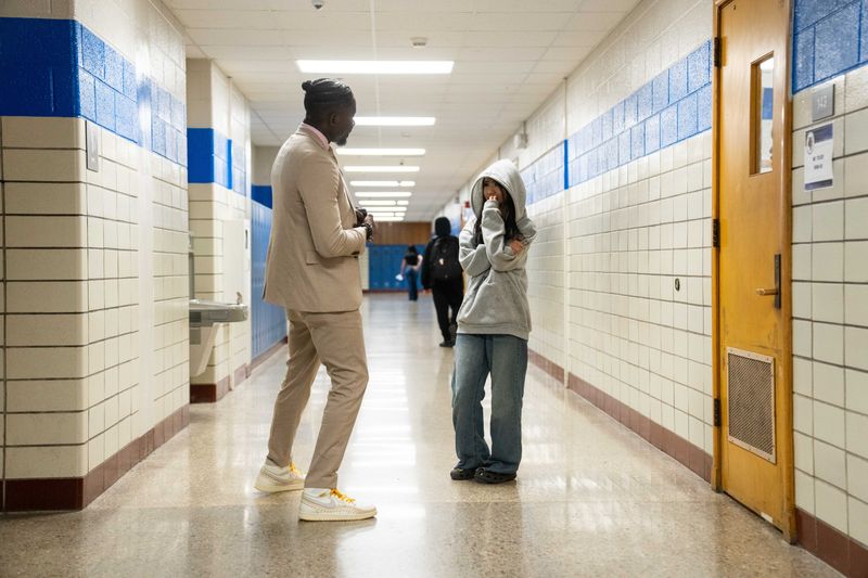 DMPS Superintendent Ian Roberts meets with a student outside of her classroom as he visits students flagged as chronically absent by the school district on Wednesday, Nov. 13, 2024, in Des Moines.