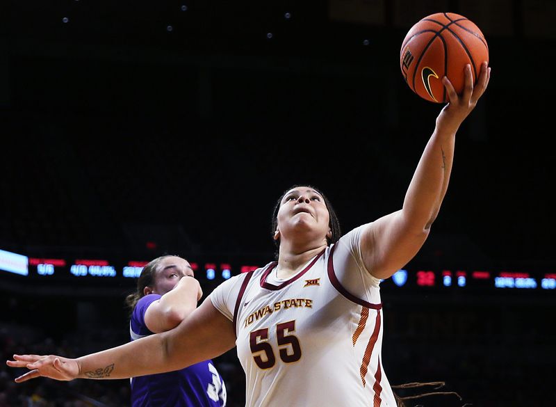 Iowa State center Audi Crooks (55) goes for a layup around St. Thomas center Jo Langbehn at Hilton Coliseum in Ames on Nov. 14, 2024.