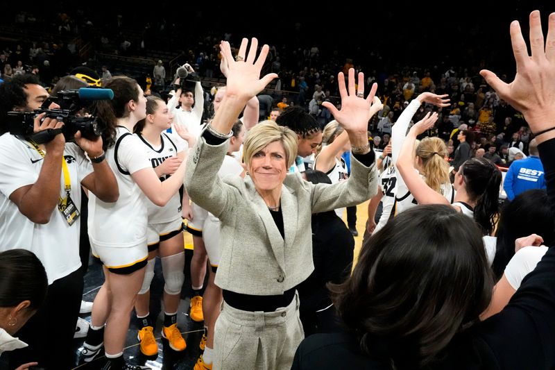 Iowa Hawkeyes head coach Jan Jensen waves to the fans along with her players after defeating the Purdue Boilermakers 84-63 Sunday, Dec. 29, 2024 at Carver-Hawkeye Arena in Iowa City, Iowa.