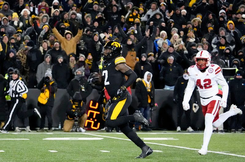 Iowa Hawkeyes running back Kaleb Johnson (2) runs to the endzone to score a touchdown as DUPLICATE***Nebraska Cornhuskers linebacker Mikai Gbayor (42) trails Friday, Nov. 29, 2024 at Kinnick Stadium in Iowa City, Iowa.