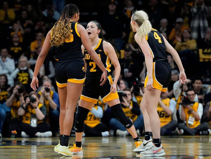 Iowa Hawkeyes guard Taylor McCabe (2), Iowa Hawkeyes forward Hannah Stuelke (45) and Iowa Hawkeyes guard Kylie Feuerbach (4) react during a game against the USC Trojans Sunday, Feb. 2, 2025 at Carver-Hawkeye Arena in Iowa City, Iowa.