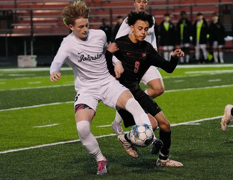Ames’ mid-fielder Adam Benbah (9) and Johnston's defender Max Aliano (16) battle for the ball during the first half at Ames High football field on April 4, 2025, in Ames, Iowa.
