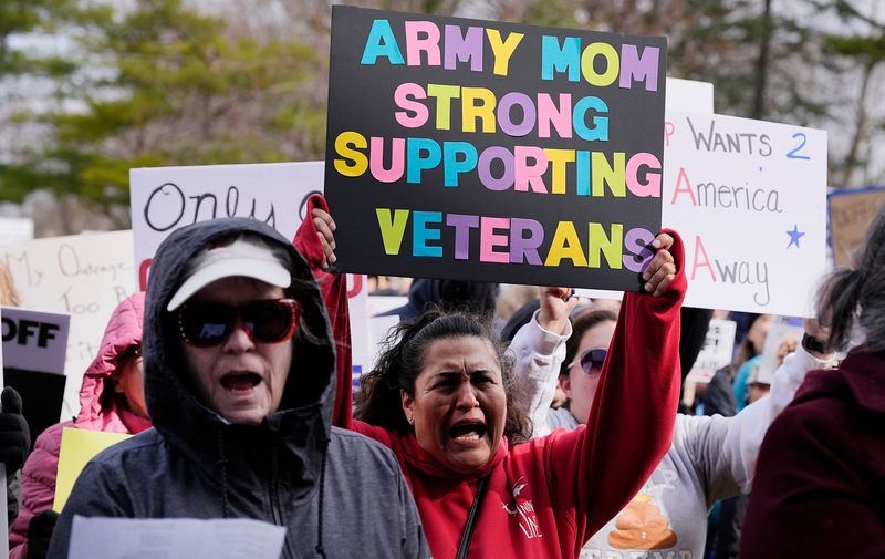 Protesters hold signs and chant in protest of President Donald Trump's administration during a 'Hands Off!' protest at Bandshell Park on Saturday, April 5, 2025, in Ames, Iowa.