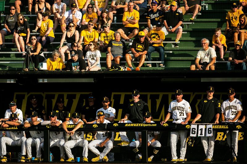 Iowa head coach Rick Heller (21) stands in the dugout with players during an NCAA Big Ten Conference baseball game against Indiana on Thursday, May 19, 2022, at Duane Banks Field in Iowa City, Iowa.