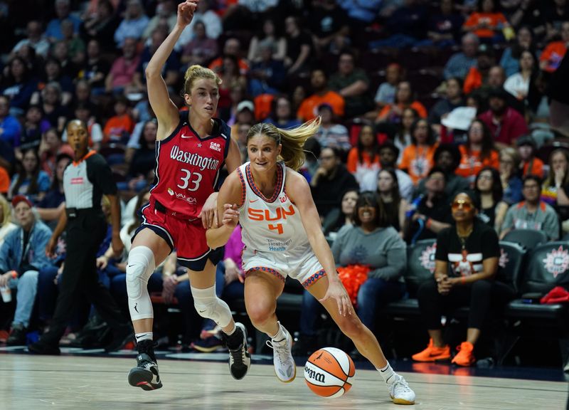 May 18, 2025; Uncasville, Connecticut, USA; Connecticut Sun guard Jacy Sheldon (4) drives the ball against Washington Mystics guard Lucy Olsen (33) in the first half at Mohegan Sun Arena.