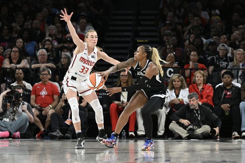 May 23, 2025; Las Vegas, Nevada, USA; Las Vegas Aces guard Tiffany Mitchell (3) makes a pass around Washington Mystics guard Lucy Olsen (33) in the third quarter of the game at Michelob Ultra Arena. Mandatory Credit: Candice Ward-Imagn Images