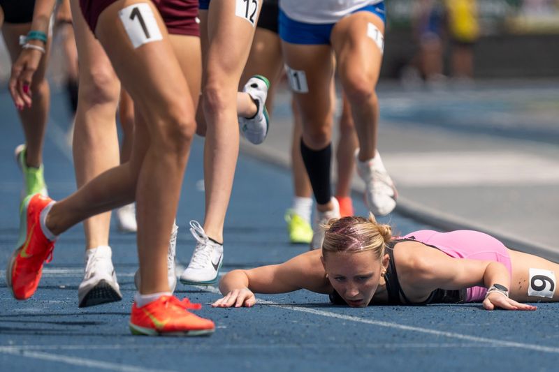Gilbert's Keira Andersen lays on the ground after winning the 3A 800 meter final during the 2025 Iowa high school state track and field meet at Drake Stadium on May 24, 2025, in Des Moines.