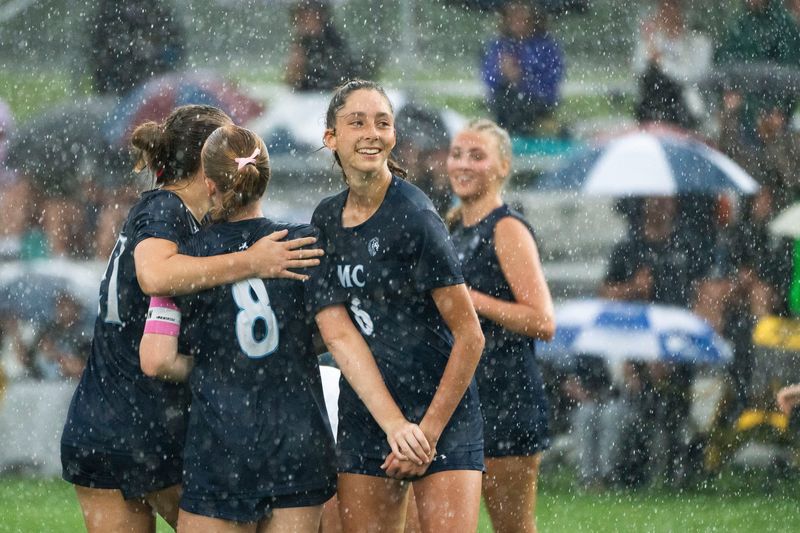 Des Moines Christian players celebrate a goal as heavy rain falls during the 2025 IGHSAU state soccer tournament at Lied Recreational Fields on June 3, 2025, in Ames.