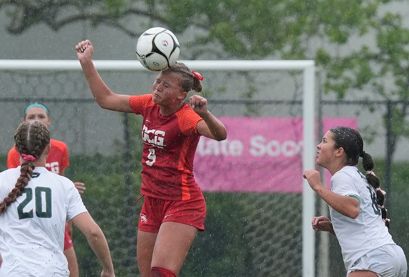 Dallas Center-Grimes defender/midfielder Anna Mikkelsen (9) heads the ball around Pella forward/midfielder Claire Smock (8)during the first half of the 2A girls Iowa high school soccer quarterfinal at Lied Recreation Athletic Center on June 3, 2025, in Ames, Iowa