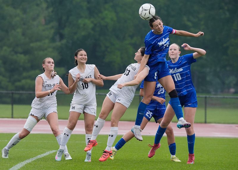 Waukee Northwest's Josie Jones (14) attempts to head the ball over Linn-Mar midfielder Sofia Romero (23) during the second half in the 3A girls state soccer championship at the Cyclone Sports Complex on Saturday, June 7, 2025, in Ames, Iowa.