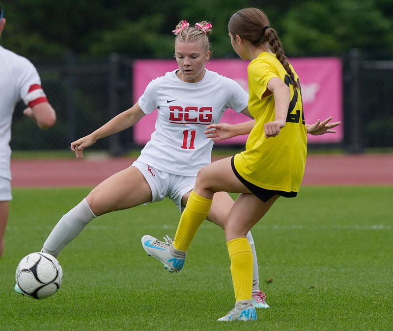 Dallas Center-Grimes defender Leah Folkerts (11) kicks the ball around Waverly-Shell Rock midfielder/forward Abby Angell (21) during the first half in the 2A girls state soccer championship at the Cyclone Sports Complex on Saturday, June 7, 2025, in Ames, Iowa.