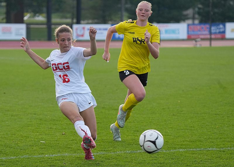 Dallas Center-Grimes midfielder Olivia Ewers (16) kicks the ball around Waverly-Shell Rock midfielder/forward Emma Smith (3) during the second half in the 2A girls state soccer championship at the Cyclone Sports Complex on Saturday, June 7, 2025, in Ames, Iowa.