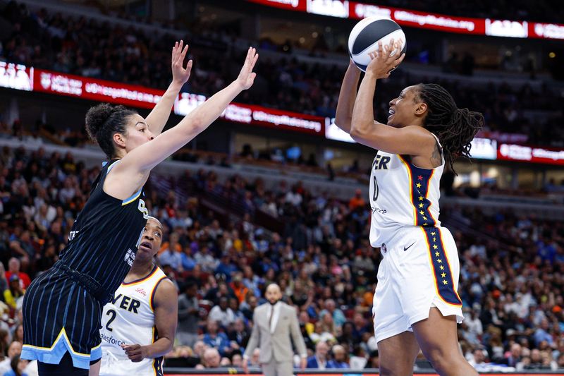 Jun 7, 2025; Chicago, Illinois, USA; Indiana Fever guard Kelsey Mitchell (0) shoots against the Chicago Sky during the first half of a WNBA game at United Center. Mandatory Credit: Kamil Krzaczynski-Imagn Images