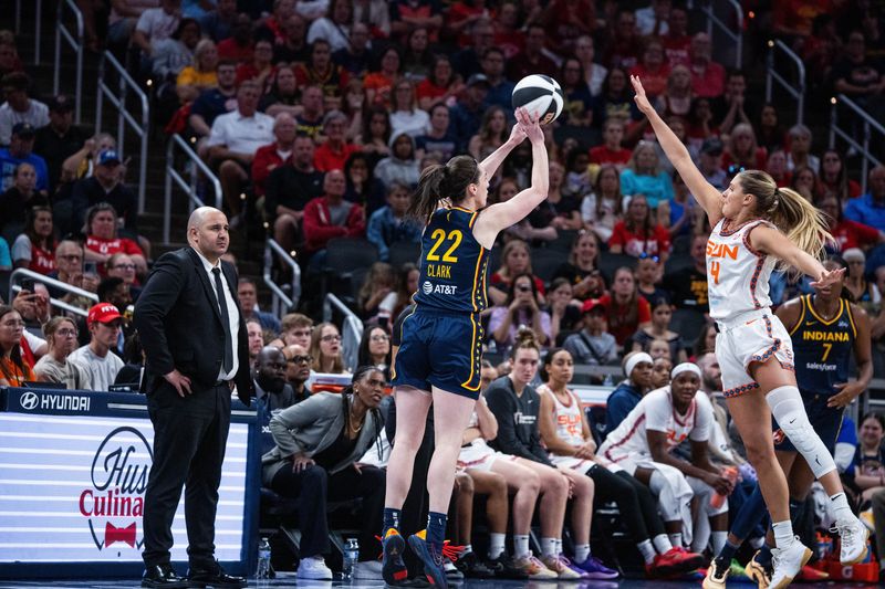 Jun 17, 2025; Indianapolis, Indiana, USA; Indiana Fever guard Caitlin Clark (22) shoots the ball while Connecticut Sun guard Jacy Sheldon (4) defends in the second half at Gainbridge Fieldhouse. Mandatory Credit: Trevor Ruszkowski-Imagn Images
