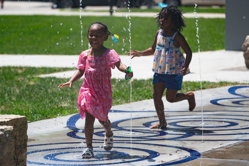 Children play in the new Western Gateway Park water feature during Juneteenth Neighbor's Day festival at Western Gateway Park on June 21, 2025, in Des Moines.