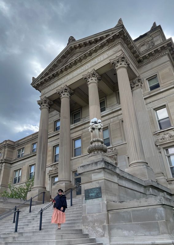 In the spirit of journalistic impartiality, Anna, who received three degrees from the University of Iowa, is posing in front of the 1908 Beardshear Hall on the Iowa State University campus in Ames, the University of Iowa’s competitive sports rival.