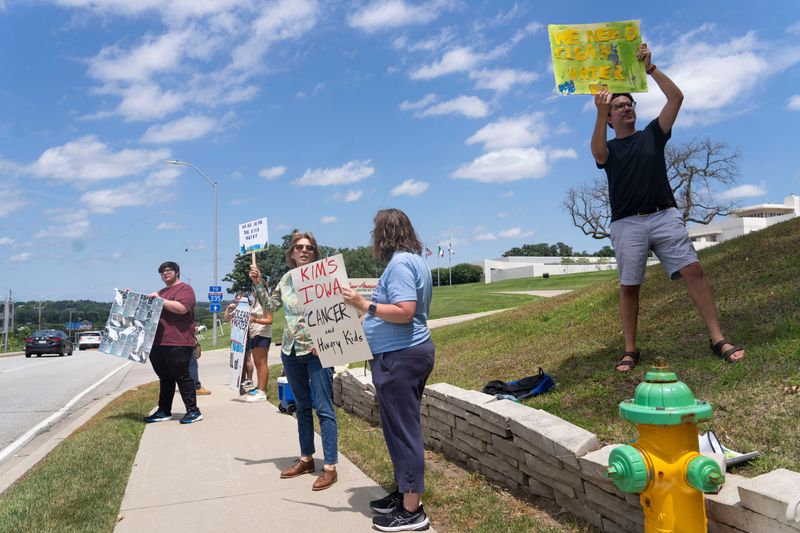 Water quality protesters gather along Fleur Drive during a groundbreaking ceremony for the Italian-American Cultural Center of Iowa on July 10, 2025, in Des Moines. The protesters sought to confront Gov. Reynolds on the state's water quality after high nitrate levels in the Des Moines and Raccoon Rivers led to an ongoing lawn-watering ban in the Des Moines metro.