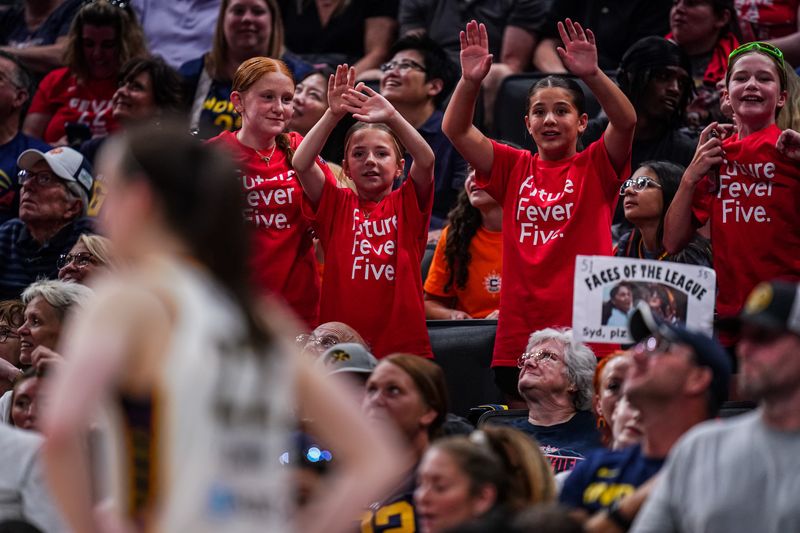Jul 15, 2025; Boston, Massachusetts, USA; Basketball fans try to get Indiana Fever guard Caitlin Clark (22) attention during a break in the action against the Connecticut Sun at TD Garden.